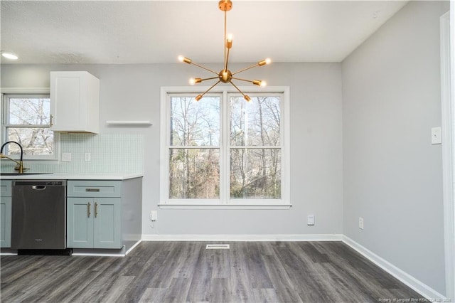 kitchen with sink, dishwasher, tasteful backsplash, a notable chandelier, and white cabinets