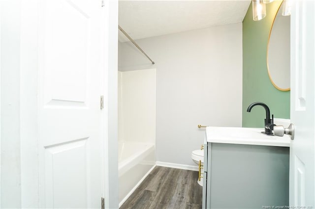 full bathroom featuring hardwood / wood-style flooring, vanity,  shower combination, and toilet