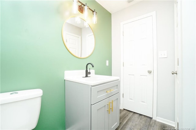 bathroom featuring hardwood / wood-style flooring, vanity, and toilet