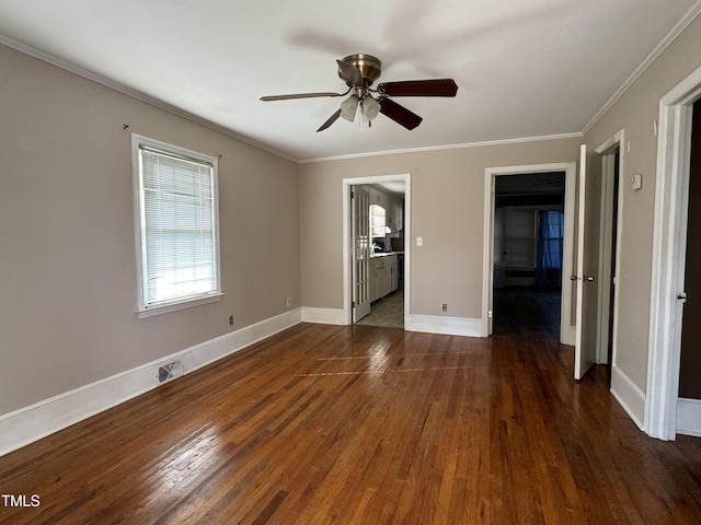 empty room featuring ceiling fan, crown molding, and dark wood-type flooring