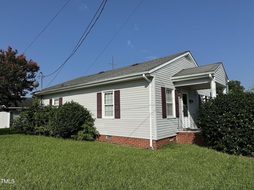 view of side of home with a lawn