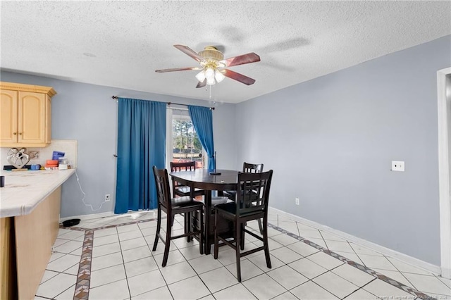 dining space with ceiling fan, light tile patterned flooring, and a textured ceiling