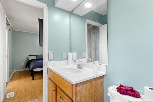 bathroom with wood-type flooring, vanity, and toilet