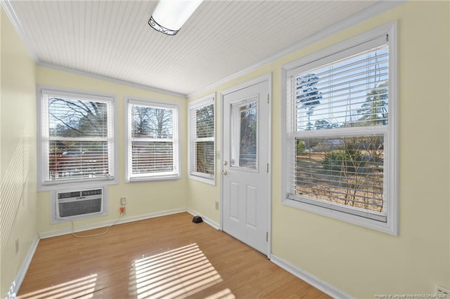 unfurnished sunroom with an AC wall unit, a wealth of natural light, and lofted ceiling