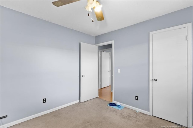 unfurnished bedroom featuring light colored carpet and ceiling fan