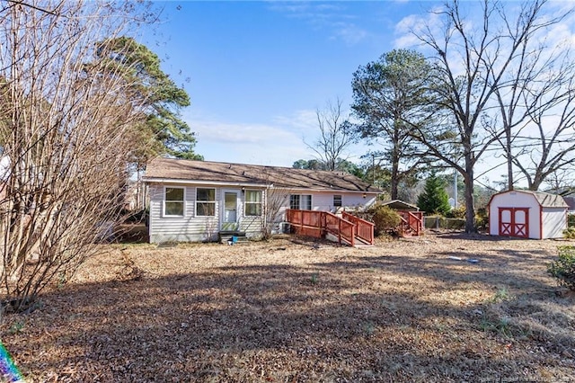 rear view of house with a deck and a storage unit