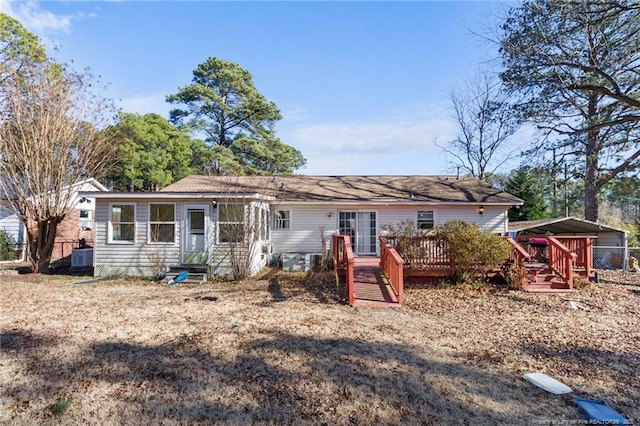 rear view of house with a carport and a deck