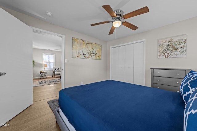 bedroom featuring light wood-type flooring, ceiling fan, and a closet