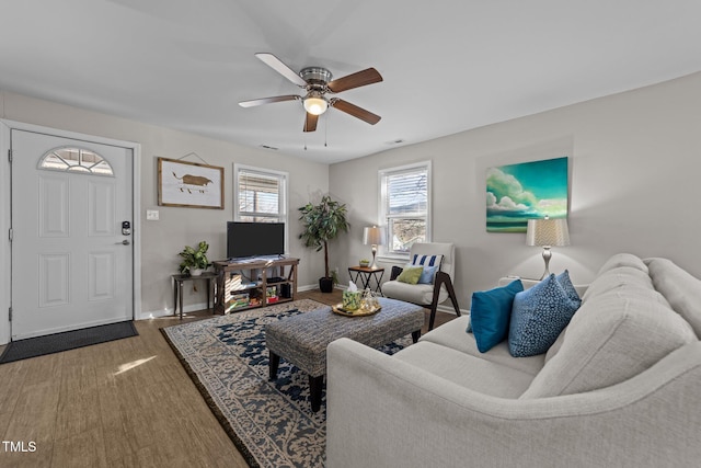 living room featuring ceiling fan and dark hardwood / wood-style floors