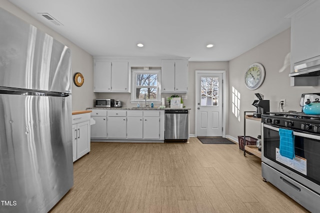 kitchen featuring sink, white cabinets, light hardwood / wood-style floors, and stainless steel appliances