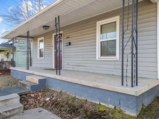 view of exterior entry featuring covered porch