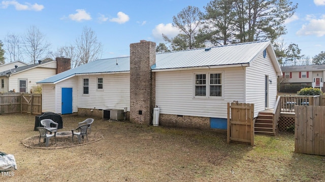 back of house featuring central air condition unit, an outdoor fire pit, and a wooden deck