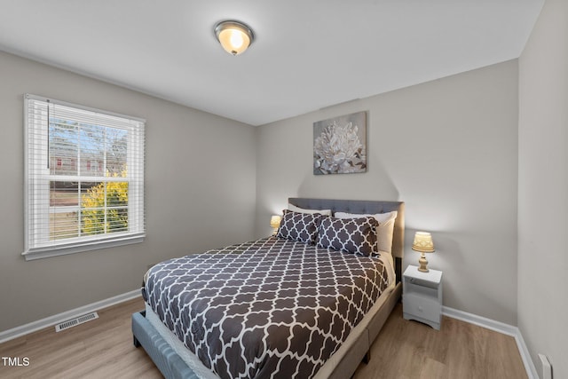 bedroom featuring multiple windows and light hardwood / wood-style floors