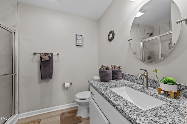 bathroom featuring a shower with shower door, hardwood / wood-style floors, toilet, and vanity