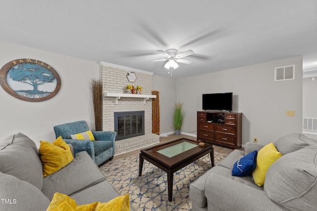 living room with light wood-type flooring, ceiling fan, and a fireplace