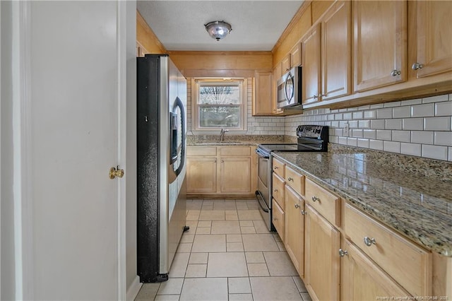 kitchen featuring sink, stone countertops, light brown cabinetry, light tile patterned flooring, and appliances with stainless steel finishes