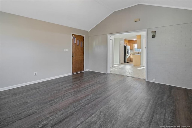 unfurnished room with dark hardwood / wood-style floors and lofted ceiling