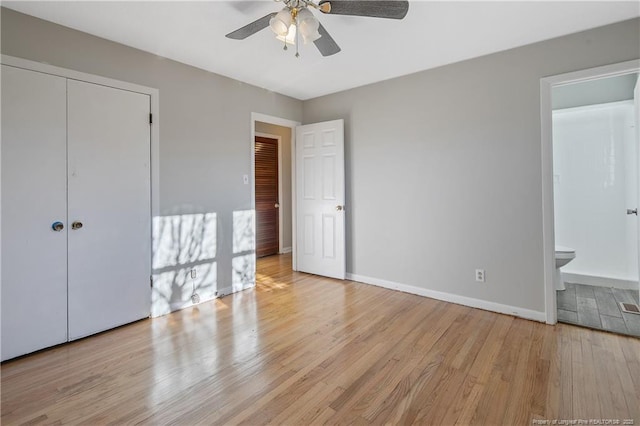 unfurnished bedroom with a closet, ensuite bathroom, ceiling fan, and light hardwood / wood-style floors