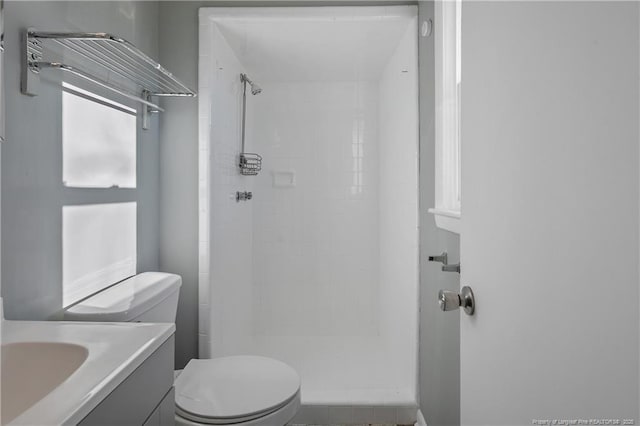 bathroom featuring vanity, toilet, and a shower