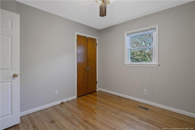 empty room with ceiling fan and light wood-type flooring