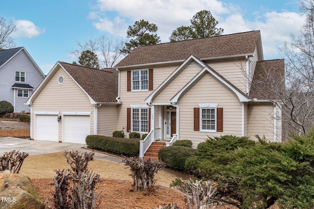 traditional-style home featuring a shingled roof, driveway, and an attached garage