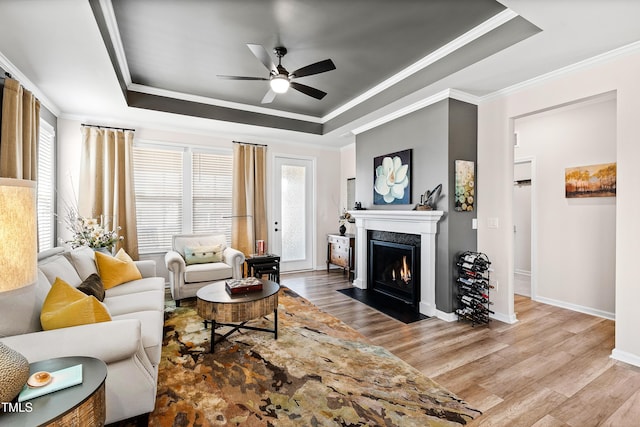 living room featuring hardwood / wood-style flooring, crown molding, and a raised ceiling