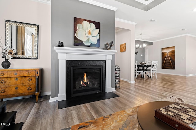 living room with hardwood / wood-style floors, a notable chandelier, and ornamental molding