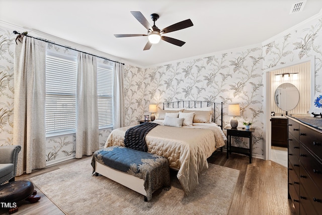 bedroom featuring hardwood / wood-style floors, ceiling fan, and ensuite bathroom