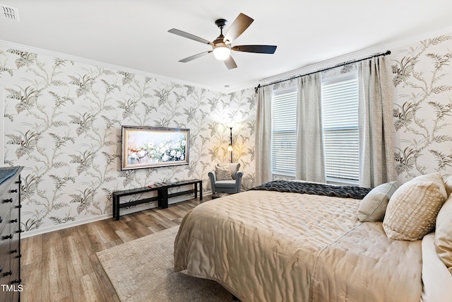 bedroom with hardwood / wood-style floors, crown molding, and ceiling fan