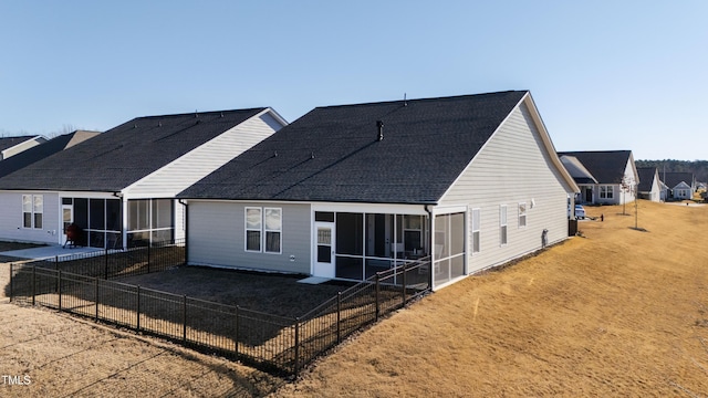 back of property featuring a sunroom and a lawn