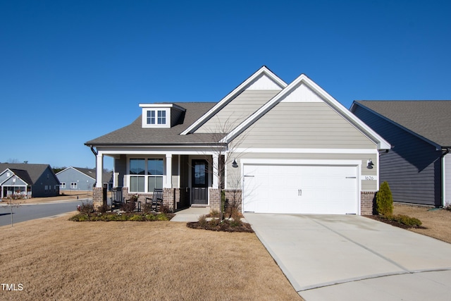 craftsman-style home featuring a garage, a front yard, and covered porch