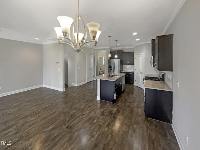 kitchen with sink, decorative light fixtures, stainless steel refrigerator with ice dispenser, an island with sink, and a notable chandelier