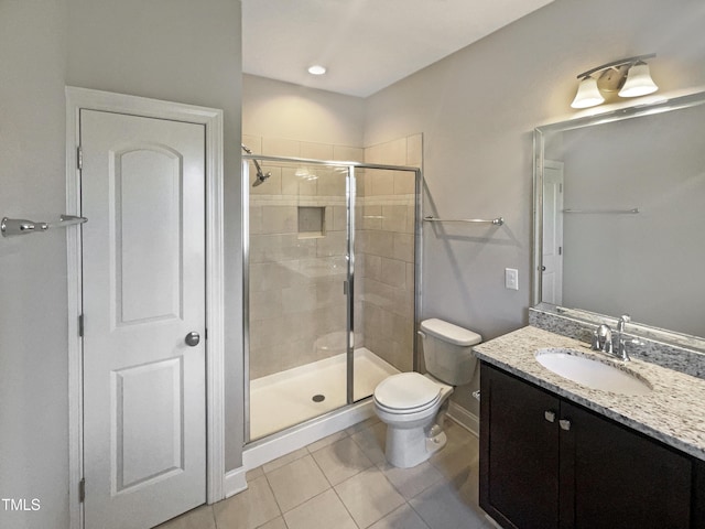 bathroom featuring tile patterned floors, vanity, toilet, and a shower with door