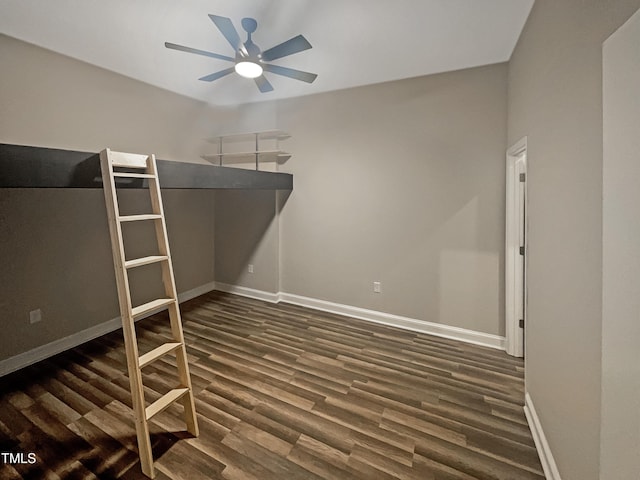 unfurnished bedroom featuring ceiling fan and dark wood-type flooring