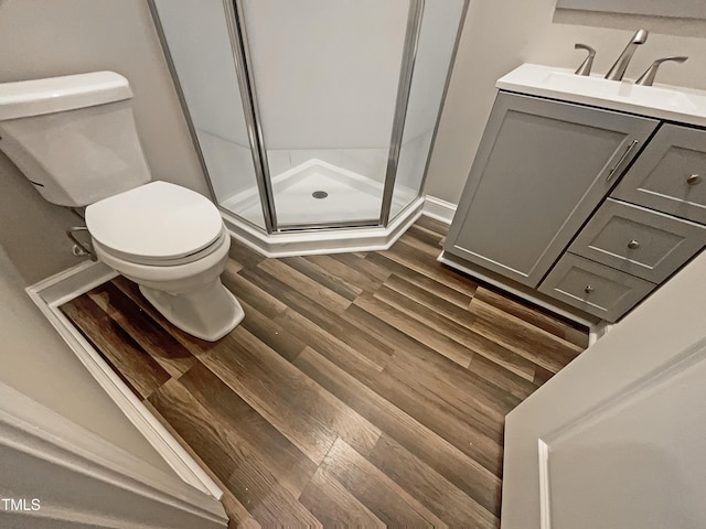 bathroom featuring hardwood / wood-style floors, toilet, an enclosed shower, and vanity