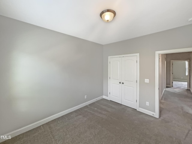 unfurnished bedroom featuring a closet and dark colored carpet