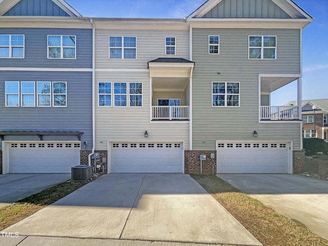 townhome / multi-family property featuring a balcony, a garage, and central AC unit