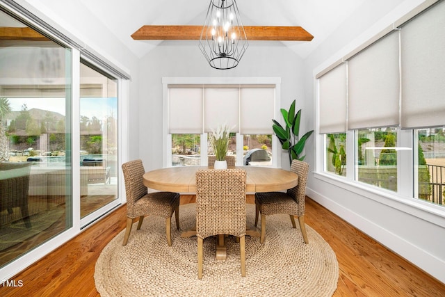 dining room featuring a chandelier, lofted ceiling with beams, and light hardwood / wood-style flooring