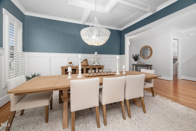 dining area featuring coffered ceiling, crown molding, a notable chandelier, beam ceiling, and hardwood / wood-style floors