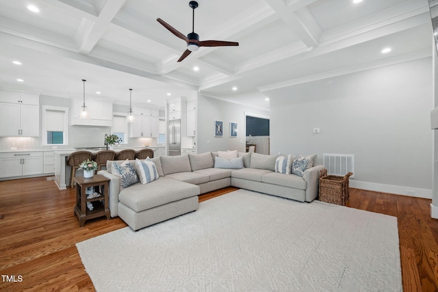 living room featuring coffered ceiling, ceiling fan, light hardwood / wood-style floors, and beamed ceiling