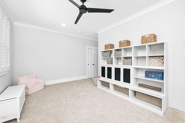 rec room with crown molding, light colored carpet, and ceiling fan