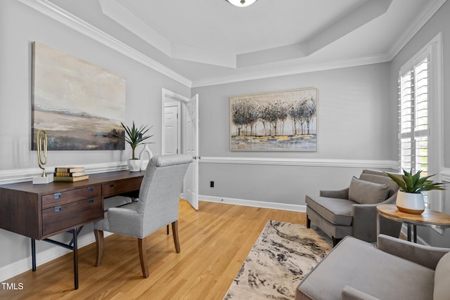 office with light wood finished floors, baseboards, a raised ceiling, and crown molding