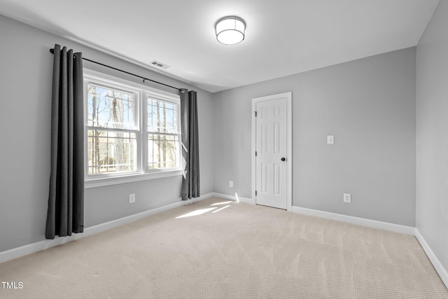 unfurnished room featuring light carpet, visible vents, and baseboards