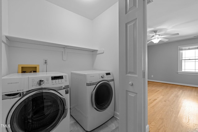 laundry room with baseboards, laundry area, separate washer and dryer, and light wood-style floors