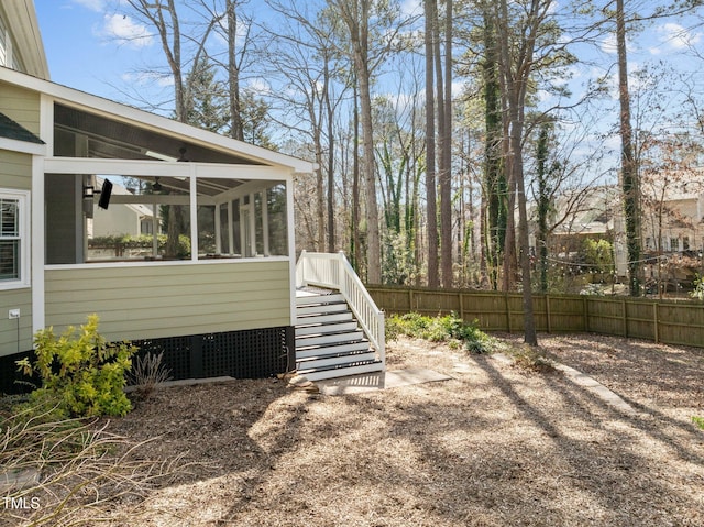 view of yard with a sunroom, stairs, and fence