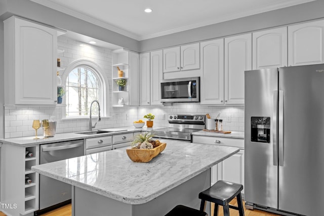 kitchen featuring open shelves, appliances with stainless steel finishes, ornamental molding, white cabinetry, and a kitchen island