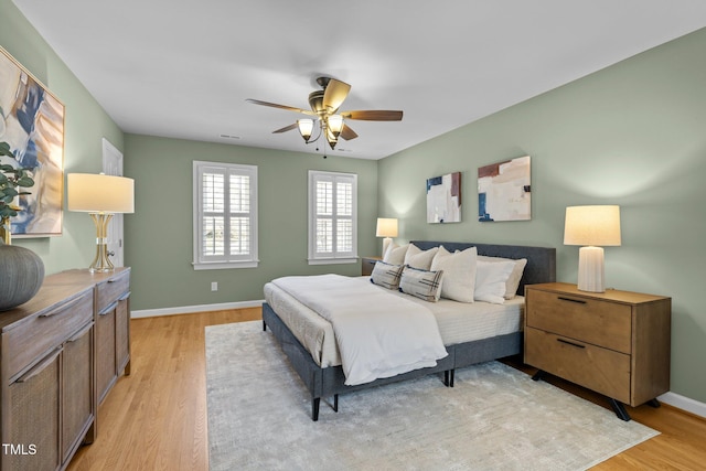 bedroom with baseboards, ceiling fan, and light wood finished floors