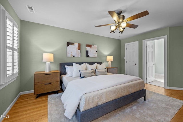 bedroom with light wood-style flooring, visible vents, and baseboards