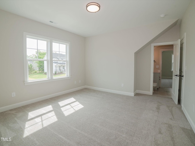 empty room with baseboards, visible vents, and light colored carpet