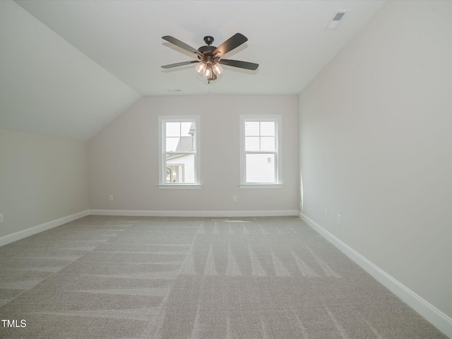 additional living space with baseboards, visible vents, light colored carpet, lofted ceiling, and ceiling fan